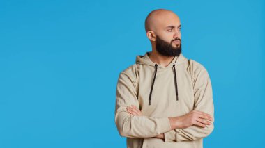 Arka planda sabırsız davranan Ortadoğulu adam, kolları çapraz çekilmiş bir şey bekleyen gergin bir adam. Arap erkek model ciddi ve dakik. Kamera 2. El kamerasıyla..