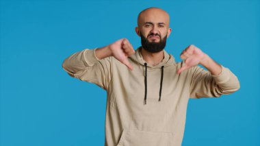 Ortadoğulu adam kamerada baş parmak işareti gösteriyor. Hoşnutsuzluk sembolü veriyor ve hayal kırıklığını sunuyor. Araplar stüdyodaki olumsuz jestlerden rahatsız olurlar. Kamera 1.