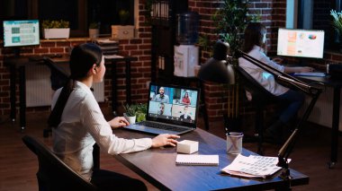 İş kadını, iş görüşmesi sırasında yönetim kuruluyla ofiste görüntülü konuşma yapıyor. Çalışan uzaktan video konferans tele-iş görüşmesinde konuşuyor, yönetimden geri bildirim alıyor