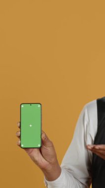 Dikey Video Restoran çalışanları stüdyoda yeşil ekranlı akıllı bir telefon olduğunu ve servis odaklı ortamlarda yemek siparişi vermeye hazır olduklarını gösteriyor. Önlüklü ve üniformalı garson müşterilere masalarda servis yapıyor.
