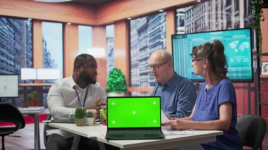 Yaşlı müşteriler danışmanıyla emeklilik planının güvenliğini tartışıyor, modern ofiste dizüstü bilgisayarlarında kroma anahtarı var. Yaşlılar hayat sigortası için emeklilik seçeneği sunuyor. Kamera B.