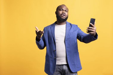 Telekonferans toplantısında arkadaşlarıyla kavga eden kızgın bir adam akıllı telefon ve stüdyo geçmişi kullanıyor. İnternet video çağrısı sırasında arkadaşlarıyla anlaşmazlık yaşayan kaba kişi