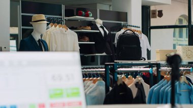 Modern giysi ve aksesuar satan boş bir moda mağazası, mağazada moda ayakkabılar ve çantalar sergileniyor. Şık giyim mağazasının içinde, gömlekleri ve pantolonları askıda duruyor. Kamera A.