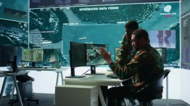 Hükümet analistleri uydu radar sistemleri olan gelişmiş bir komuta merkezinde çalışıyor, izleme faaliyetlerini denetliyor ve gerçek zamanlı verileri yorumluyorlar. Ulusal çıkarları koruyorum. Kamera B.