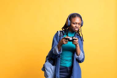 Portrait of cheerful woman playing videogames, holding controller, isolated over studio background. Gamer smiling, having fun by participating in PvP online multiplayer game using console system clipart