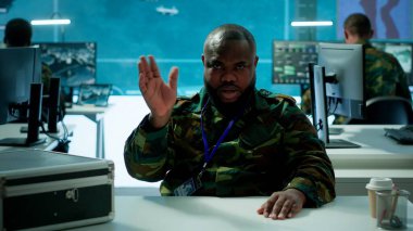 Askeri subay, modern komuta merkezindeki güvenli bir video konferansına katılarak uydu bilgilerini aktarıyor. Ulusal güvenlik operasyonları için federal işbirliği. Kamera A.