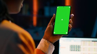 Öğrenci, ekonomi kursu araştırması için nakit planı yazılımını incelerken telefon düzeni üzerinde yeşil ekran kullanıyor. Masrafları ve kazançları öğrenen bir kız boş bir telif alanına bakar. Kamera A.