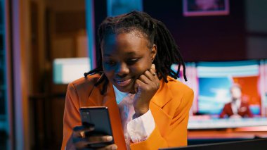 Üniversite öğrencisi ödevini laptopta yapıyor ve telefonda mesajlaşıyor, sosyal medya uygulamalarını kontrol etmek için okul tatilinin tadını çıkarıyor. Görev arayan ve akıllı telefon kullanan bir kız. Kamera A.