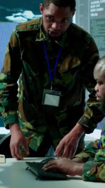 Uydu sistemleri hakkında toplanan kritik bilgileri ele alan modern bir operasyon merkezinde dikey video askeri personel, saha görevlerini destekleyen gerçek zamanlı veriler. Ulusal ordu protokolleri