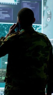 Dikey Video Askeri bir görev kontrol merkezindeki telefona cevap verir, potansiyel tehditleri ve gerçek zamanlı verileri takip etmek için gelişmiş teknoloji ve uydu görüntüleriyle çalışır. İstihbarat