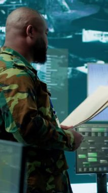 Dikey Video Askeri personeli, yüksek teknolojili bir gözetleme odası komuta merkezinde siber güvenlik operasyonları ve gözetleme sistemlerini yönetiyor. Asker ulusal güvenlik için veri koruması sağlar. Kamera.