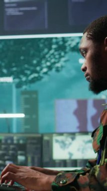 Vertical Video Bilişim uzmanı, komuta merkezindeki yeni bir savunma harekatı için gerekli gerçek zamanlı verileri toplamak amacıyla yapay zeka sistemini izliyor. Yoğun bir görev için güvenlik protokolleri