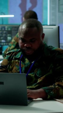 Vertical Video Askeri İstihbarat Uzmanı, komuta kulesindeki savunma operasyonları için ulusal protokolleri ve stratejik görevleri sağlamak için yüksek teknoloji uydu sistemleri ve kapalı devre radar kullanıyor.