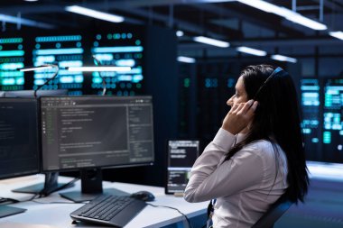 Veri merkezindeki yönetici bilgisayar üzerinde çalışıyor, müşterilere teknik destek sağlıyor, sorun yaratıyor. Müşteriler tarafından istenilen teknik müdahaleleri gerçekleştiren yüksek teknoloji sunucu merkezi çalışanı