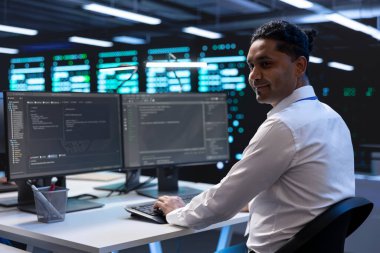 Veri merkezinin elektronik yaşam süresini uzatmak ve devre dışı kalmaktan kaçınmak için yıllık check-up yapan bir yönetici. Sunucu odasındaki çalışan bilgisayar kullanarak sunucu altyapı bileşenlerini izliyor