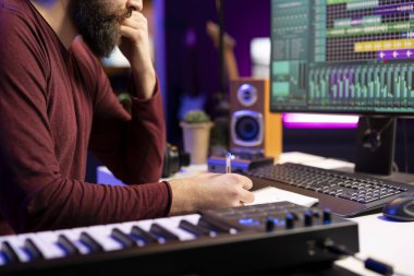 Müzisyen kendi stüdyosunda yeni bir şarkı besteleyip notalar alıyor, şarkıları kaydetmeden önce şarkı sözleri yazıyor. Şam yazılımı araçları ve yaratıcılığıyla müzik üreten şarkı yazarı.