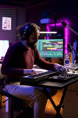 Şarkı sözü yazarı, ses dosyalarını kaydetmek için Dave yazılımını kullanarak ev stüdyosunda Midi Control piyano notaları çalıyor. Elektronik klavyede melodi çalan genç müzisyen, post prodüksiyon.