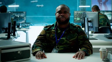 Keşif uzmanı, yüksek teknoloji kontrol odasındaki çevrimiçi bir video görüşmesinde ulusal savunma programını geliştirmek için uzak ekiplerle istihbarat ve izleme çabalarını koordine ediyor. Kamera A.