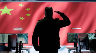 Üniformalı Çinli ordu subayı büyük ekrandaki kritik verileri izliyor. Ulusal bayrak, propaganda için kullanılan askeri komuta merkezi olan ordu operasyon odasında sunuluyor. Kamera A.