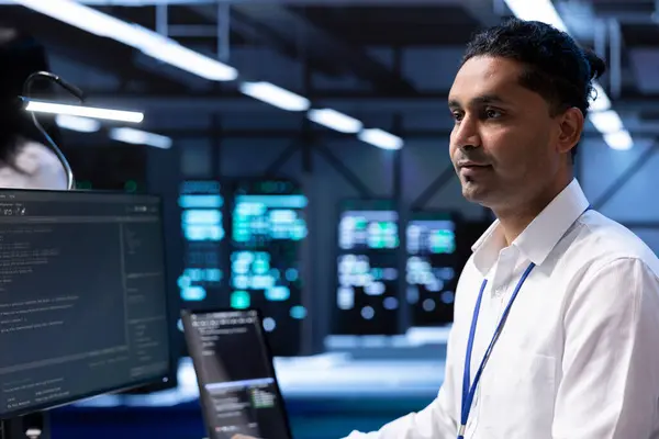 stock image Technician in high tech facility housing supercomputers, storage devices and networking parts providing vast amounts of computing resources. Specialist doing server racks maintenance