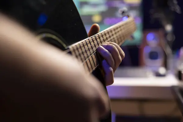 stock image Songwriter playing acoustic guitar accords in home studio, working with electronic audio gear to record new music. Artist musician implementing acoustical engineering techniques. Close up.