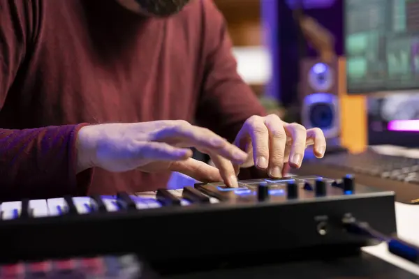 Stock image Audio engineer works with recording gear in his home studio, learning to use mixing console and pre amp knobs to add sound effects on soundtracks. Artist editing new tunes, production techniques.