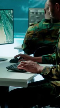 Görev kontrol merkezindeki dikey video askeri uzmanları uydu görüntülerini analiz etmek için bilgisayar ve büyük ekran üzerinde modern teknoloji kullanıyorlar. Uzman istihbarat için potansiyel tehditleri izliyor