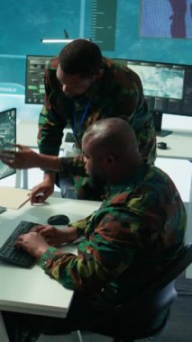 Uydu sistemleri hakkında toplanan kritik bilgileri ele alan modern bir operasyon merkezinde dikey video askeri personel, saha görevlerini destekleyen gerçek zamanlı veriler. Ulusal ordu protokolleri
