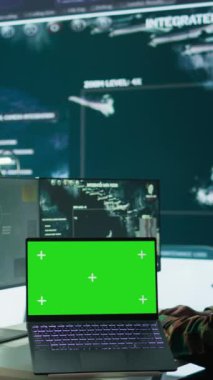 Dikey video bilişim uzmanı izole edilmiş krom anahtar ekranın yanında gerçek zamanlı bilgi topluyor, komuta noktasında yüksek teknoloji donanımı var. Saha operasyonları ve stratejik operasyonlar için istihbarat işleme