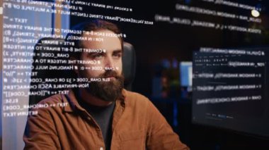 Evden programlama yaparken bilgisayar ekranında AR hologramına bakan bir teknisyen. Uzaktan çalışan, kod satırlarını görselleştirmek için arttırılmış gerçeklik teknolojisi kullanıyor