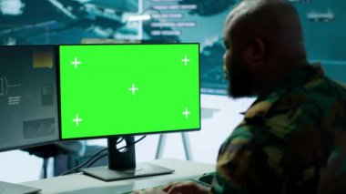 Askeri uzman, önemli savunma görevlerini desteklemek için yüksek teknoloji donanımlı bir operasyon üssünde çalışan model ekranın yanındaki uydu görüntüleme verilerini idare ediyor. Stratejik taktikleri koordine ediyor. Kamera A.