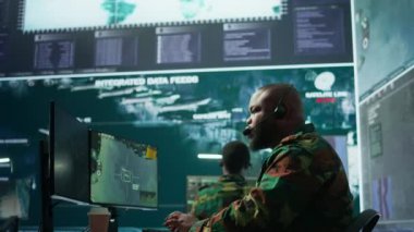 Askeri denetim odasında ordu personeli izleme sistemleri, verileri birleştiren ve stratejik görevleri koordine eden askerler bulunuyor. Karar verme ve verimliliği destekleyin. Kamera B.