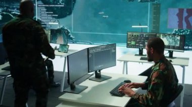 Kontrol odasında yapay zeka ile çalışan bir asker, CCTV sistemlerindeki canlı verileri işliyor. Saha görevlerini, savunma operasyonlarını, ulusal güvenliği destekleme çabaları. Kamera B.