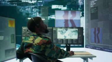 Kontrol odasındaki hükümet istihbarat memurları gözetim operasyonlarını yönetir, gerçek zamanlı verileri analiz eder ve ulusal çıkarları korumak için güvenlik önlemlerini koordine ederler. Gizli Servis. Kamera B.