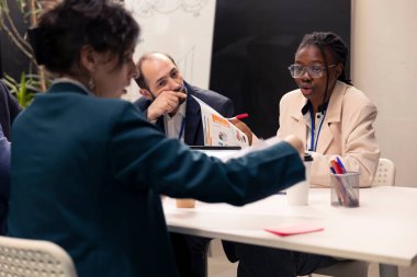 Bir konferans sırasında kaynak tahsisi girişimleri üzerinde çalışan bir grup meslektaş, iş hedefleri ve hedefleri doğrultusunda önemli bütçe tahsisi kararları alıyor. Çalışanlar gözden geçirme stratejileri.