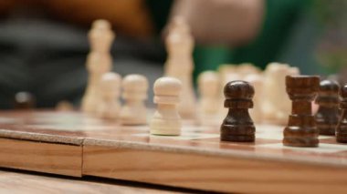 Rahat bir ev ortamında satranç oynayan, masa oyunu aktiviteleri sırasında strateji hamleleri düşünen mutlu yaşlılar. Stratejik entellektüel hobilerin zevki, işin beyni. Kamera A.