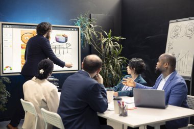 İş adamlarından oluşan bir ekip interaktif kuruldaki istatistik ve bilgi grafiklerini inceliyor ve gelişim için bilgi toplamak üzere güçlerini birleştiriyor. İş arkadaşları yasal değişiklikleri tartışıyor.