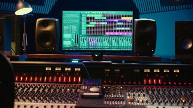 Profesyonel kayıt stüdyosundaki ses geçirmez oda, sürgülü ve faders paneli stereo ekipman. Ses kayıt yazılımıyla profesyonel prodüksiyon alanı.