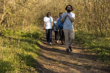 Gönüllü bir grup gönüllü ormandaki çöpleri temizliyor, atık çantalarını alıyor ve evlerine gidiyorlar. Ekosistemi temizlemeye gönüllü olan tatmin olmuş insanlar.