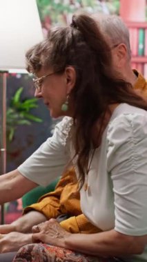 Dikey video sunucusu kadın kocasıyla günlük dozda ilaç ve vitamin alıyor, sağlık ve kişisel bakım için reçeteli ilaç tedavisinden sonra. İlaç kullanan yaşlı bir çift.