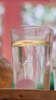 Dikey video. Yaşlı adam ve kadın coşkulu vitamin haplarını bir bardak suya atıp günlük sağlıklı yaşam takviyelerini içiyorlar. Tedavi gören yaşlılar, kişisel bakım