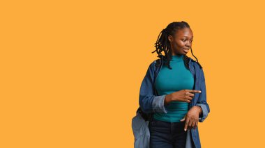 Afro-Amerikalı bir kadın her yeri işaret ediyor, reklam yapıyor, izleyicilerle konuşuyor. Sunum yapan genç kız, metin kopyaları, stüdyo arkaplanı, kamera B