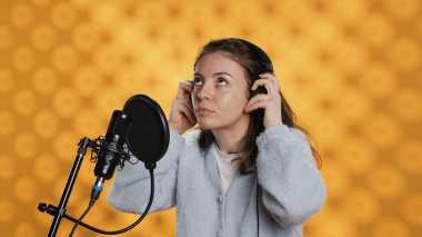 Woman with headset on starting job, narrating book word for word to produce audiobook. Narrator putting headphones on, using mic to produce digital recording of novel, studio background, camera A clipart