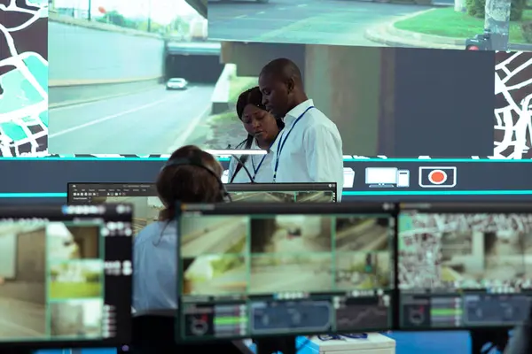 stock image African american team leaders inspecting delivery trucks activity in traffic, ensuring easy order shipment with satellite navigation through radar system. Analyzing CCTV surveillance footage.