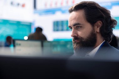 Genel müdür, yatırımcılardan daha fazla fon almadan önce maliyet ve gelir rakamlarını hesaplar ve yıllık kilit performans ölçümlerini inceler. İş analisti satış raporları üzerinde çalışıyor..