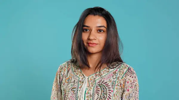 stock image Portrait of cheerful friendly indian woman smiling, looking pleased, isolated over studio background. Happy person in traditional attire having positive facial expression, feeling satisfied, camera B