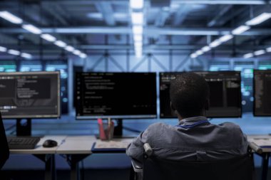 Kapsayıcı sunucu merkezi çalışma alanında engelli kişi verilerin tehditlerden korunmasını sağlıyor. Afrikalı Amerikalı tekerlekli sandalye kullanıcısı veri merkezi altyapısını koruyor