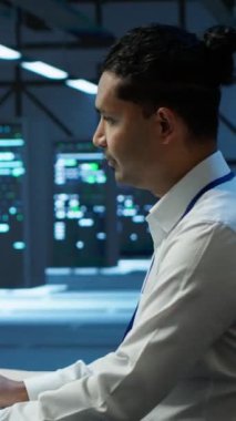 Veri merkezinde sunucuları, işletim sistemlerini ve yazılım programlarını yöneten iyimser yönetimin dikey video portresi. Sunucu merkezinin güvenli ve düzgün çalışmasını sağlayan neşeli bir uzman.