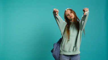 Hüsrana uğramış kadın işaret işareti gösteriyor, onaylamıyor ve olumsuz geri bildirim sunuyor. Hayal kırıklığına uğramış kız el hareketlerinden hoşlanmıyor, stüdyo geçmişi, kamera B