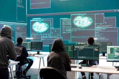 Siber savunma uzmanı, siber operasyonlara ve dijital güvenliğe odaklanan büyük bir ekrandaki verileri inceliyor. Hacker siber suç faaliyetlerine karşı koruma sağlıyor.